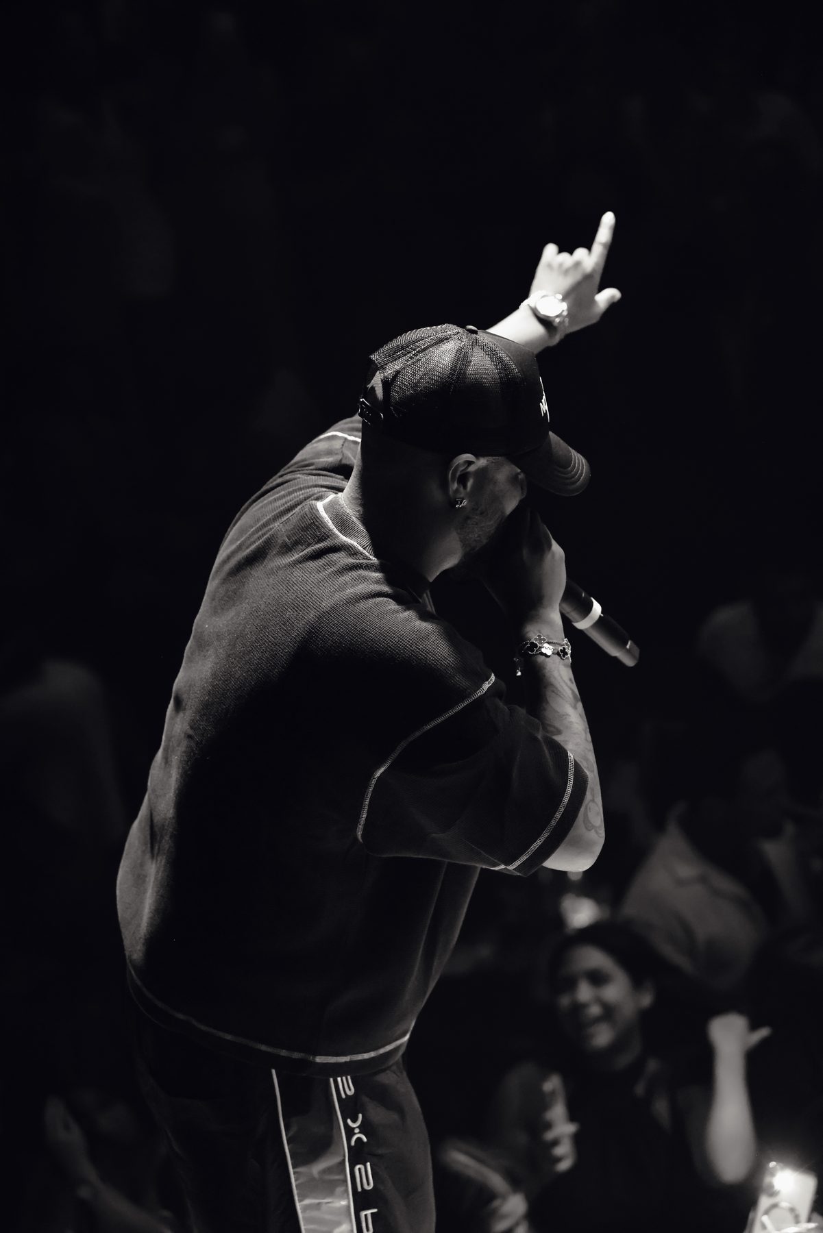 Artista de espaldas en el escenario con la mano en alto, foto de Anabel Betancourt